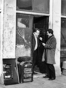 361211 Afbeelding van twee mannen in gesprek in de deuropening van de metaalhandel op het adres J.P. Coenstraat 61 te ...